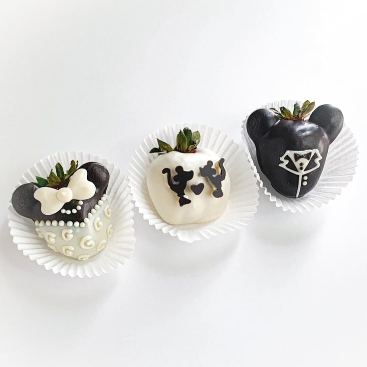 These three black and white Mickey & Minnie Mouse Wedding Strawberries show Minnie in her dress, Mickey in his tux and the two of them kissing.