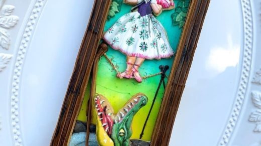 3-D cookie of the Haunted Mansion's Stretching Room Portrait with a woman on a rickety tightrope and an alligator below her