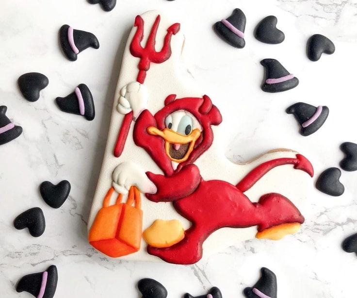 Donald Duck dressed in a red devil costume holding a red pitchfork