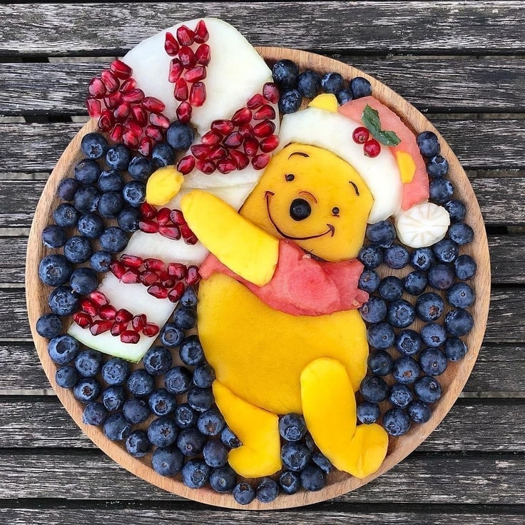 This Winnie the Pooh Christmas Fruit Platter has Pooh wearing a Santa hat and holding a giant candy cane.