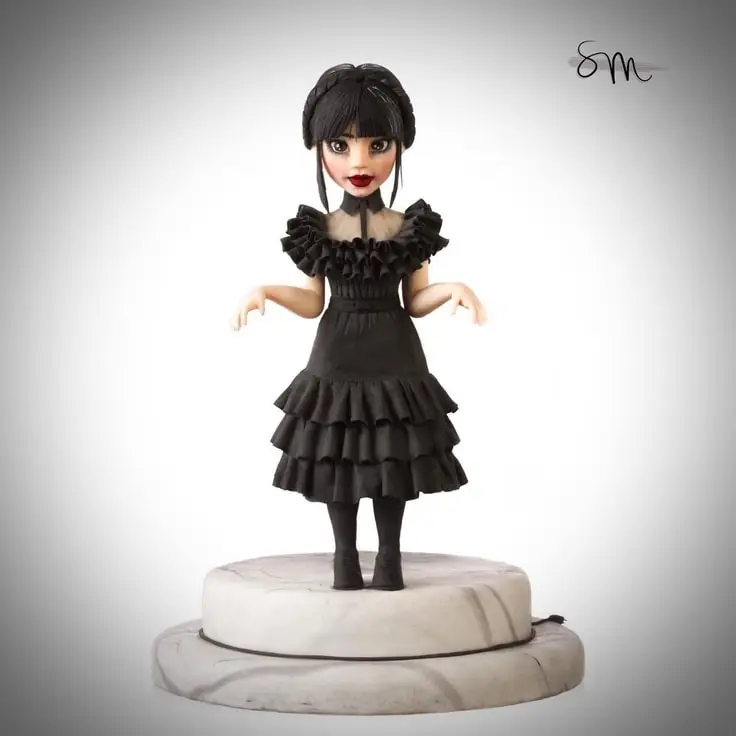 This cake topper features Jenna Ortega as Wednesday Addams.