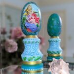 A hand painted Wooden Little Mermaid Easter Egg on top of an ornate stand