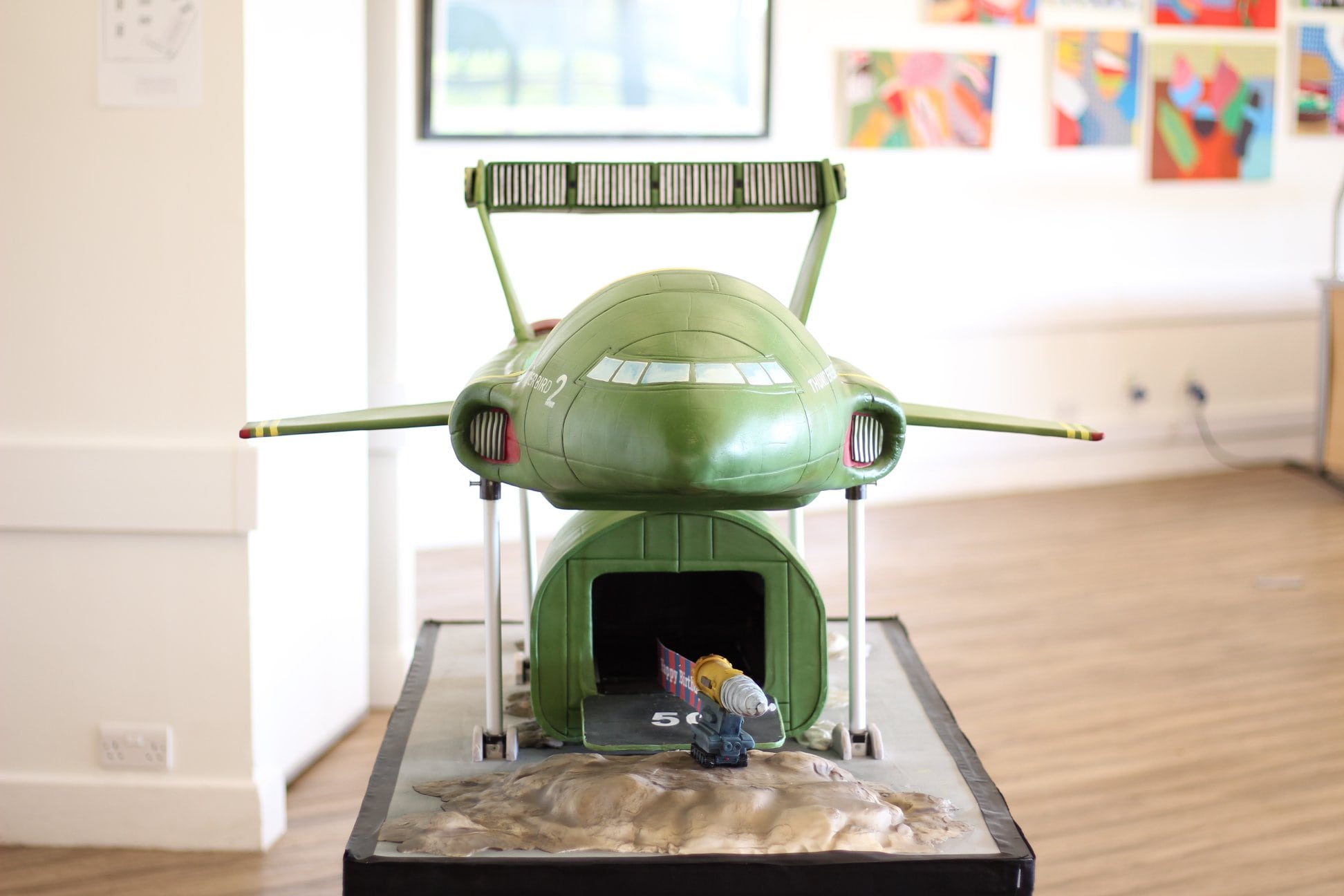 This is a front view of the Thunderbird 2 Cake. The frame is risen and you can see inside the cargo area.