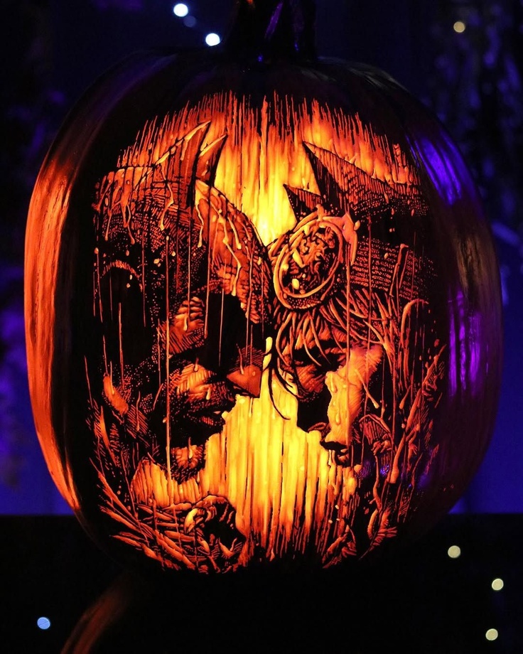 This pumpkin carving shows the faces of Batman and Catwoman about to kiss in the rain.