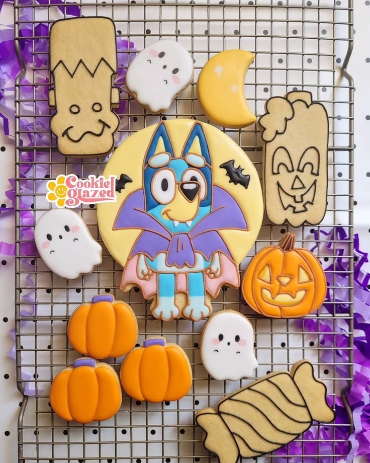 The cookies on a drying rack. Some of the cookies only have black outlines on them.